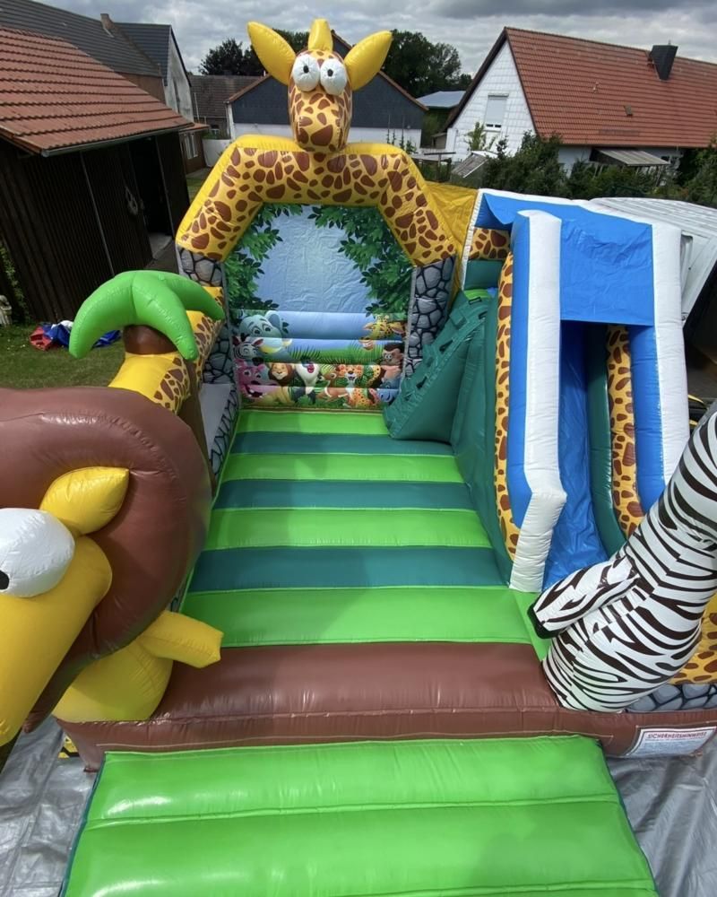 Hüpfburg Dschungel aufgebaut in einem Garten, Blick über Sprungfläche und Rutsche