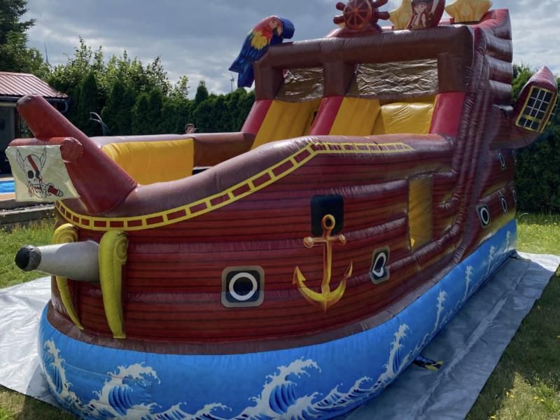 Hüpfburg Piratenschiff mit Papagei, Anker und Wellen, aufgebaut auf einer Wiese